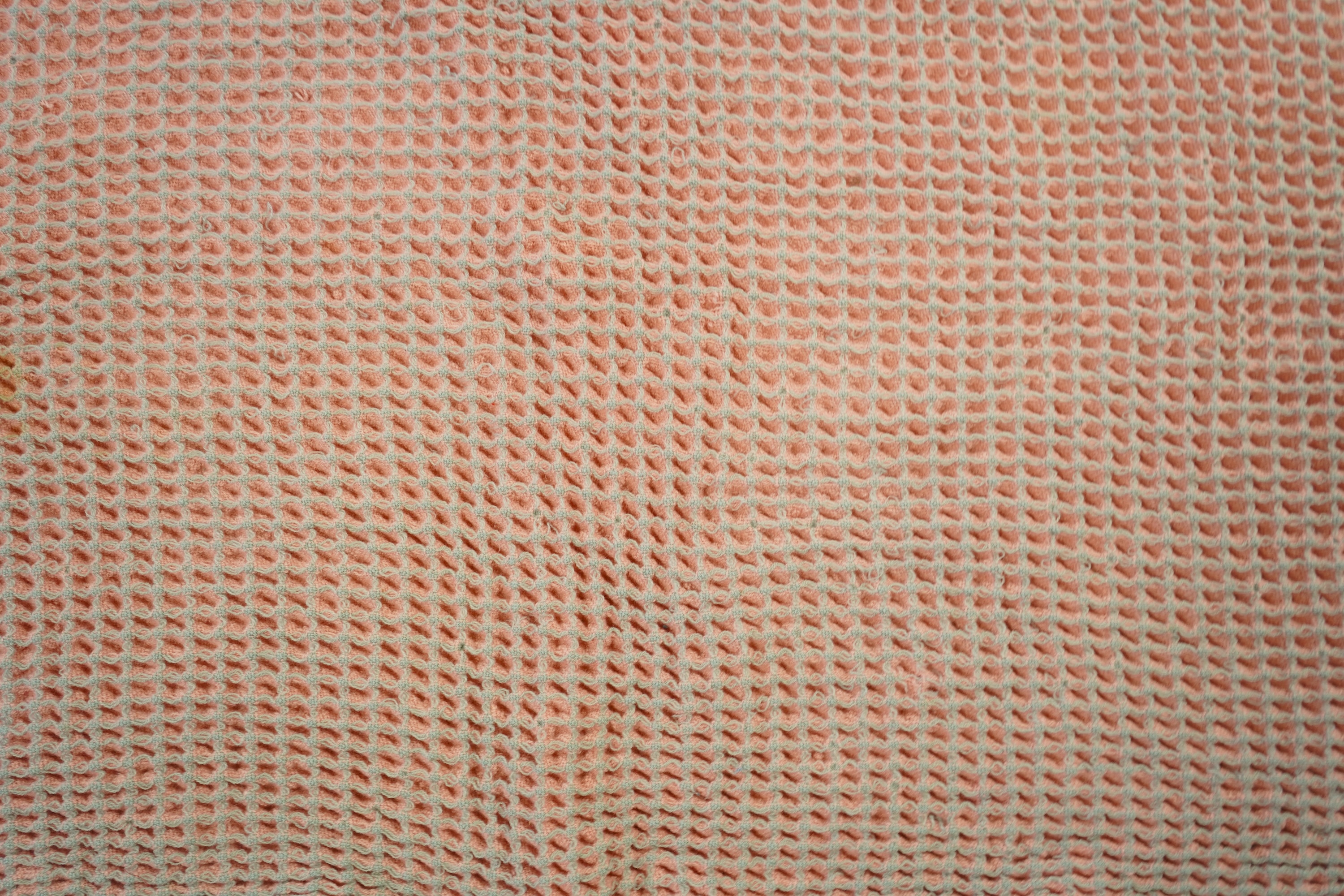 An unusual pink and grey honeycomb woven wool Welsh blanket. 194cm x 176cm. Condition - various threads have pulled and there is a small stain.
